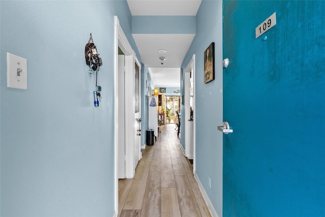 hallway with light hardwood / wood-style floors