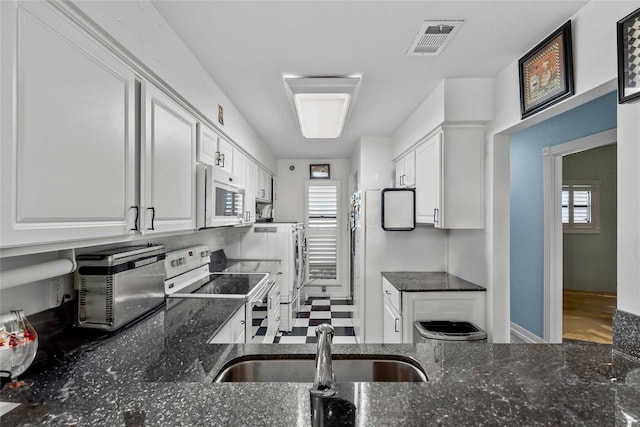 kitchen featuring white cabinetry, stainless steel electric stove, and a healthy amount of sunlight