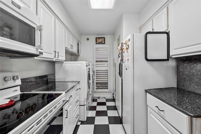 kitchen with separate washer and dryer, white cabinets, dark stone counters, and white appliances