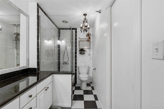 bathroom featuring tiled shower, toilet, vanity, and an inviting chandelier