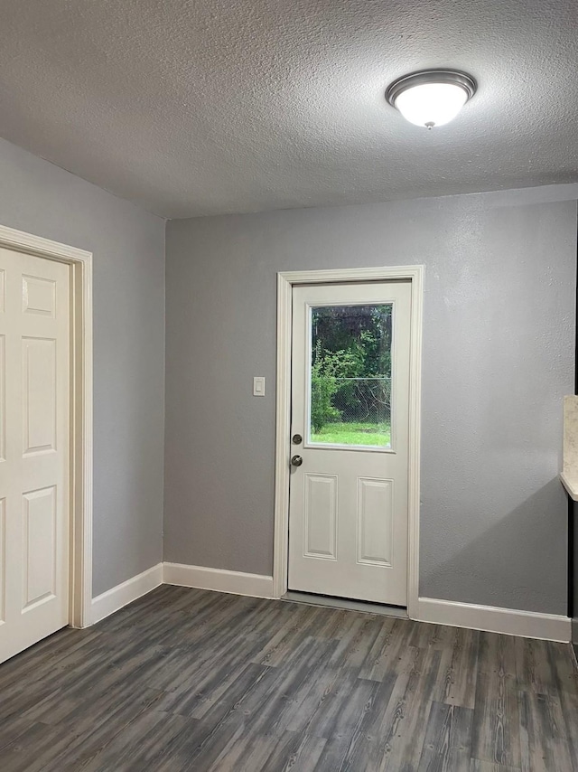 entryway featuring dark wood-type flooring and a textured ceiling