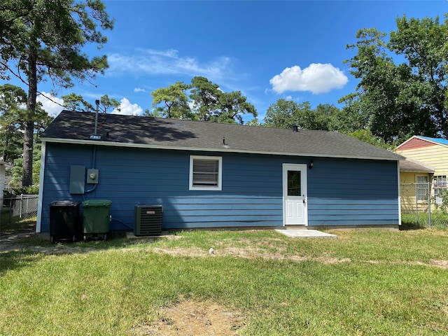 back of property with a lawn and central air condition unit