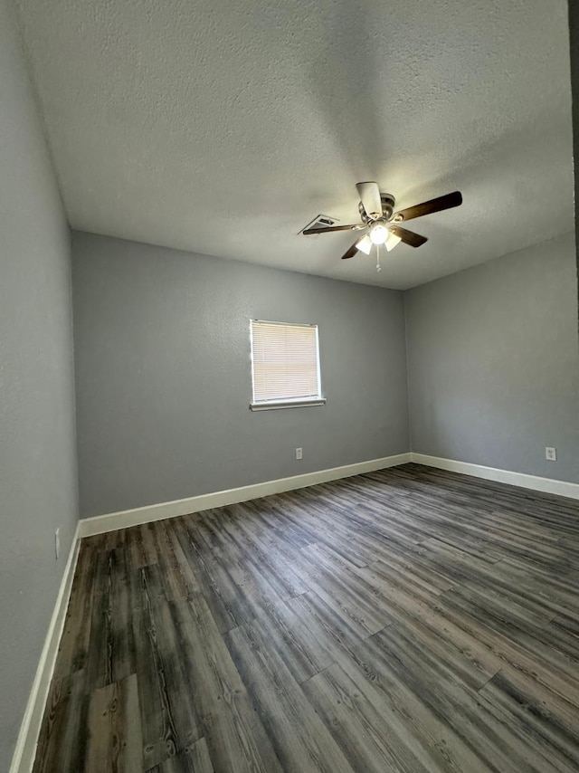 spare room featuring dark hardwood / wood-style flooring and a textured ceiling