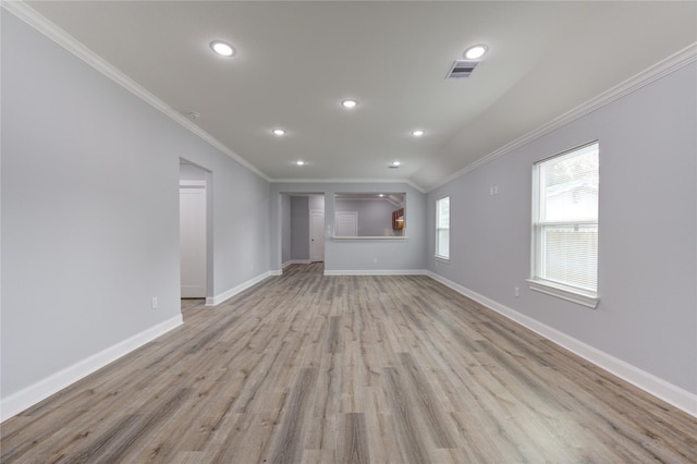 unfurnished living room featuring light hardwood / wood-style floors, crown molding, and vaulted ceiling