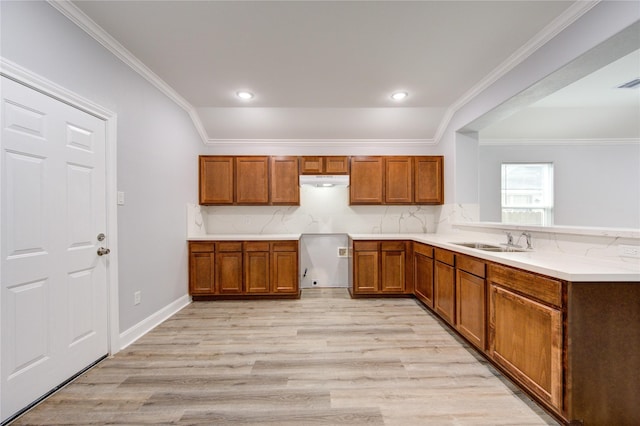 kitchen with lofted ceiling, crown molding, sink, light wood-type flooring, and tasteful backsplash