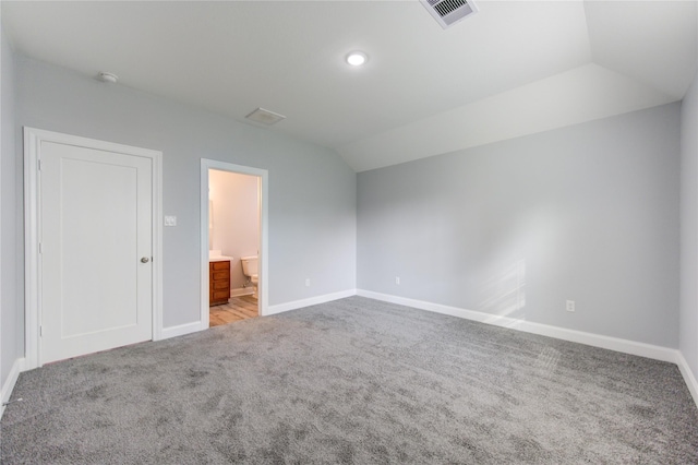 unfurnished bedroom featuring carpet flooring, connected bathroom, and vaulted ceiling