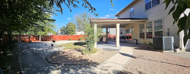 view of yard with central AC and a patio