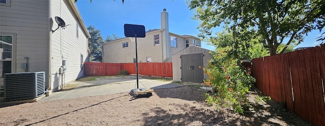 view of yard featuring a storage shed, central AC unit, and a patio area