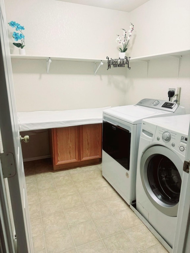 laundry area featuring cabinets, washer and clothes dryer, and light tile patterned floors