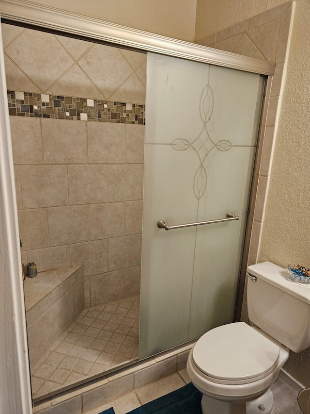 bathroom with toilet and a shower with shower door