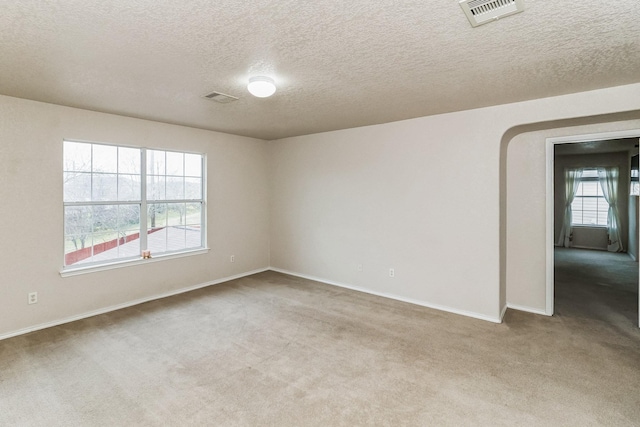 unfurnished room featuring a textured ceiling and light colored carpet