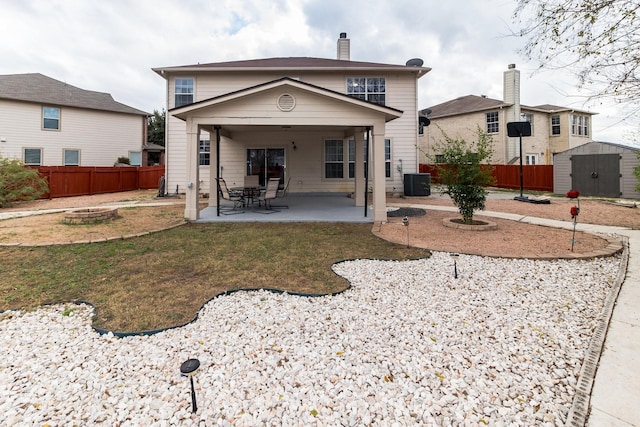 back of house with a storage unit, cooling unit, a lawn, and a patio area