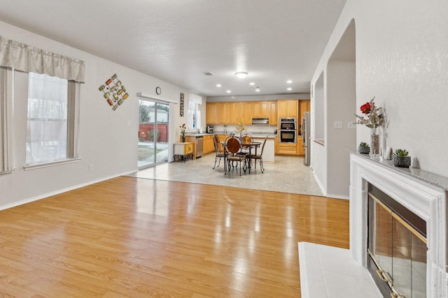 dining room featuring light wood-type flooring and a tile fireplace