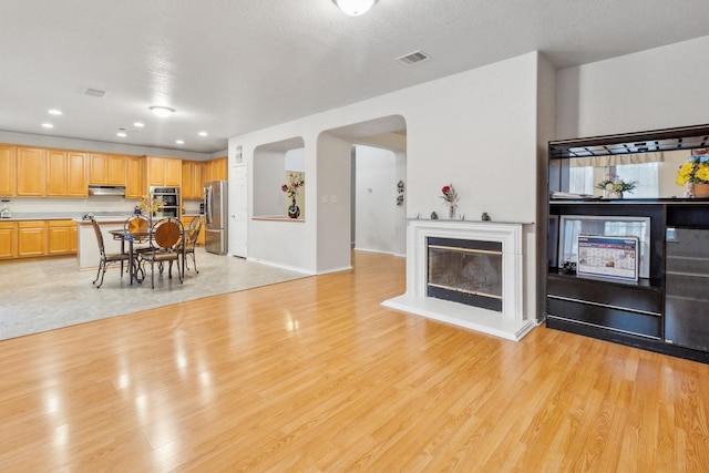 living room featuring light hardwood / wood-style flooring and a textured ceiling