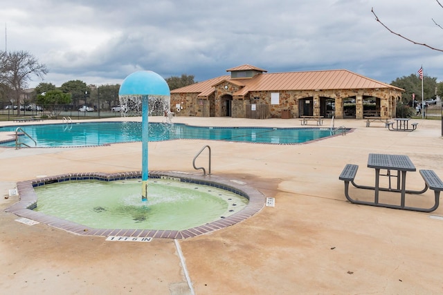 view of pool with a hot tub