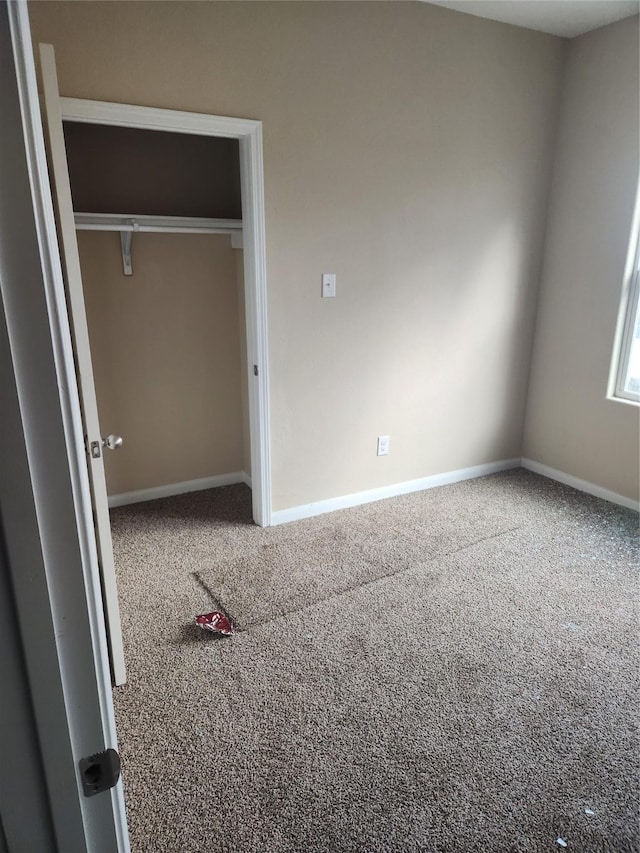 unfurnished bedroom featuring carpet flooring and a closet