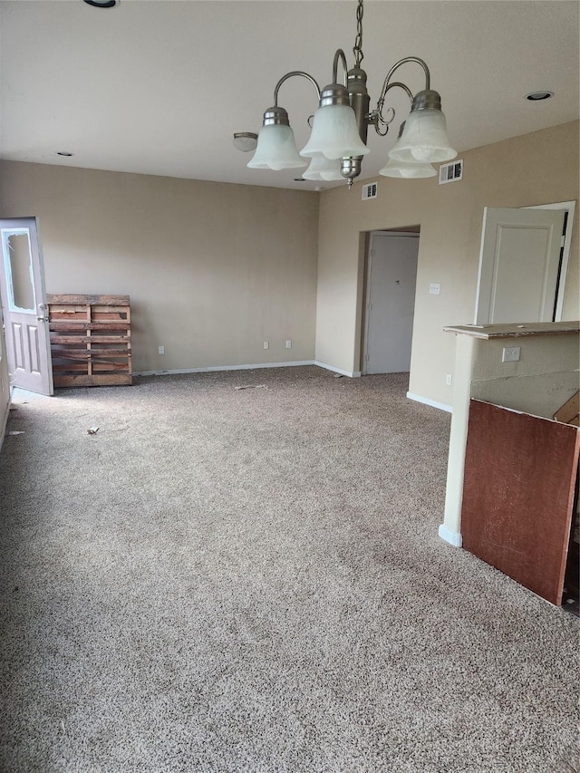 unfurnished living room with carpet and a notable chandelier