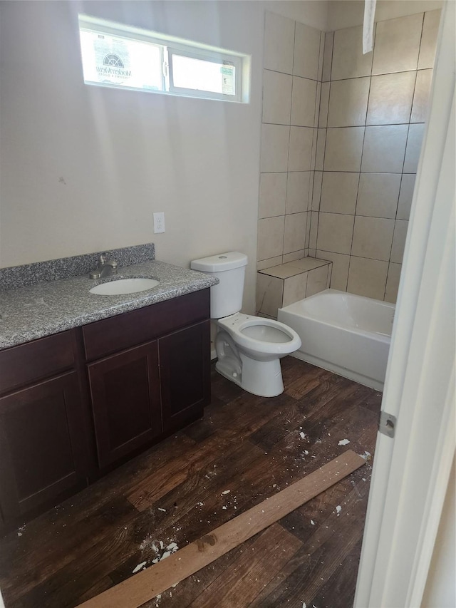 full bathroom with hardwood / wood-style flooring, vanity, toilet, and tiled shower / bath