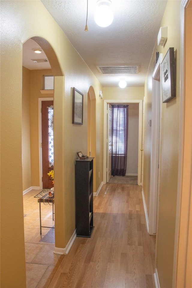 hall featuring a textured ceiling and hardwood / wood-style flooring