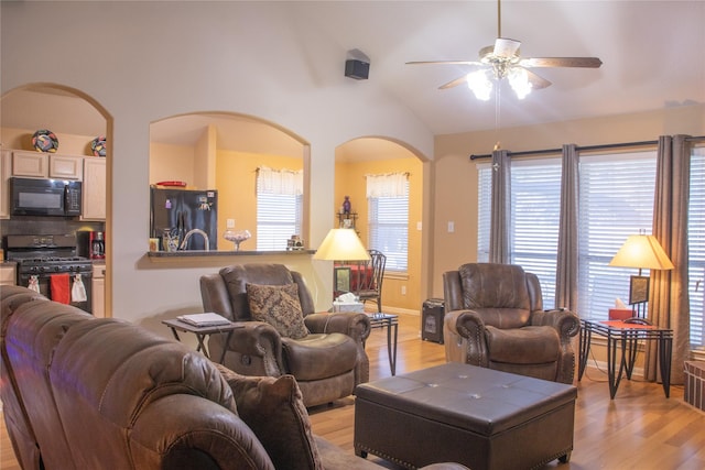 living room with light wood-type flooring, ceiling fan, and lofted ceiling