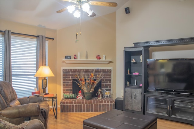 living room featuring ceiling fan, a fireplace, lofted ceiling, and hardwood / wood-style flooring