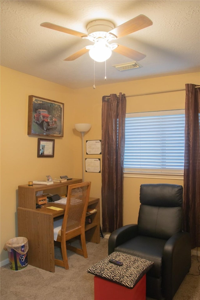 carpeted office space featuring ceiling fan and a textured ceiling