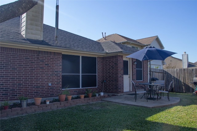 back of house with a patio and a lawn