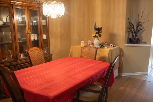 dining area with dark hardwood / wood-style flooring and an inviting chandelier