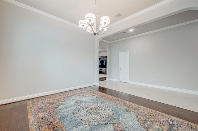 unfurnished room featuring ornamental molding, a notable chandelier, and hardwood / wood-style flooring