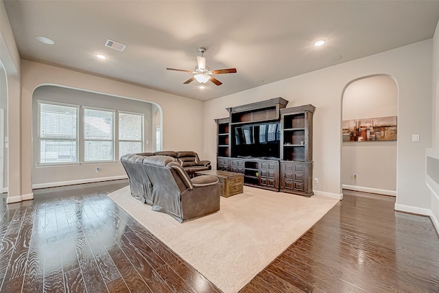 living room with ceiling fan and dark hardwood / wood-style flooring