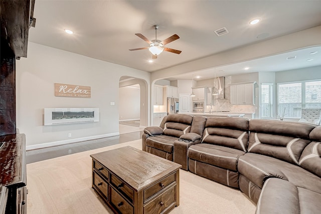 living room featuring ceiling fan and light hardwood / wood-style floors