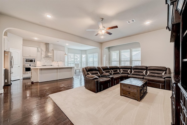 living room with ceiling fan, dark hardwood / wood-style flooring, and sink