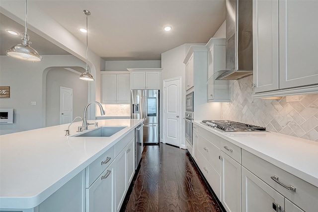 kitchen with dark hardwood / wood-style flooring, sink, wall chimney range hood, decorative light fixtures, and white cabinets