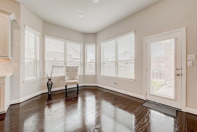 unfurnished room featuring a healthy amount of sunlight and dark hardwood / wood-style flooring