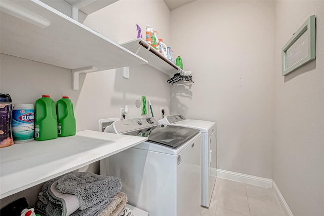 laundry area featuring washing machine and clothes dryer and light tile patterned floors