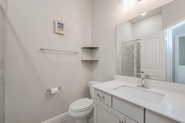 bathroom featuring a shower, vanity, and toilet