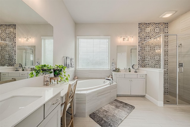 bathroom with vanity and shower with separate bathtub