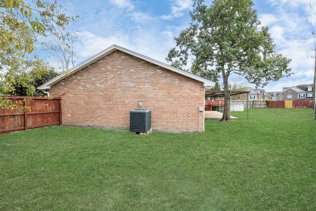 view of side of property with central air condition unit and a lawn