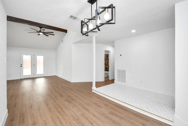 unfurnished living room featuring ceiling fan, lofted ceiling with beams, light wood-type flooring, and a textured ceiling