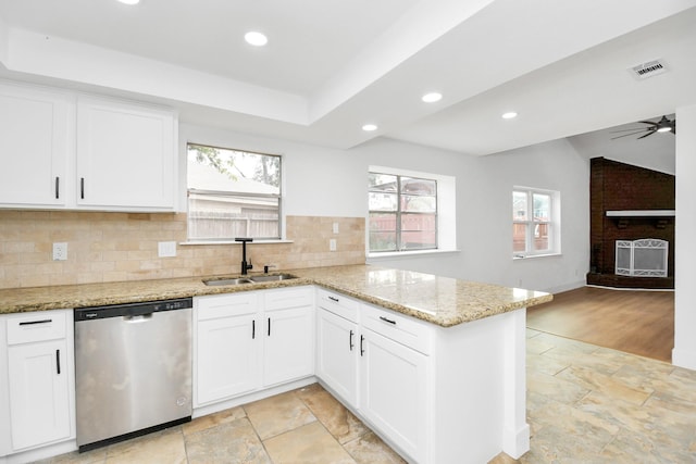 kitchen with white cabinetry, sink, light stone counters, stainless steel dishwasher, and kitchen peninsula