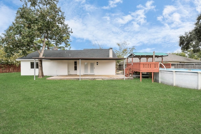 back of house with a lawn, french doors, and a pool side deck