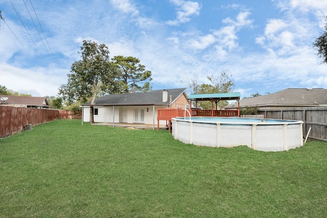 back of house featuring a yard and a fenced in pool