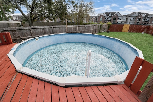 view of swimming pool featuring a yard and a deck