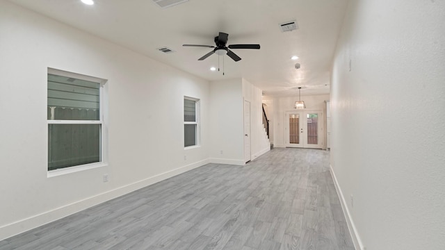 unfurnished living room featuring ceiling fan, french doors, and light wood-type flooring