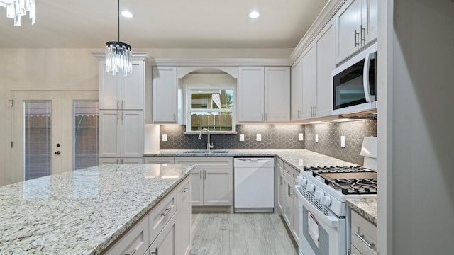 kitchen with french doors, white appliances, sink, pendant lighting, and white cabinetry