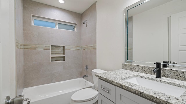 full bathroom featuring tiled shower / bath combo, toilet, and vanity