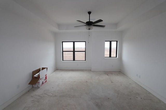 empty room with a tray ceiling and a ceiling fan