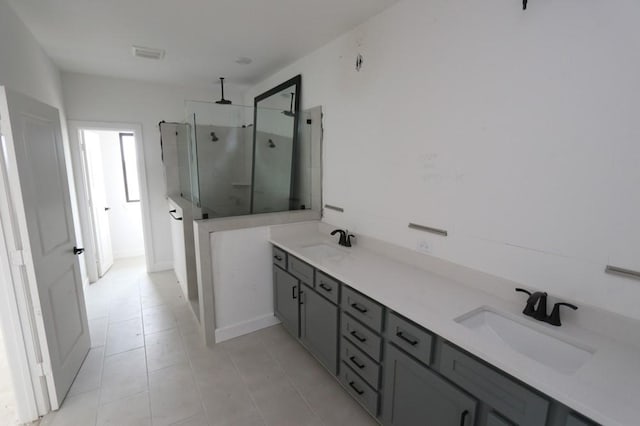 full bath with tile patterned flooring, a sink, visible vents, and a shower stall