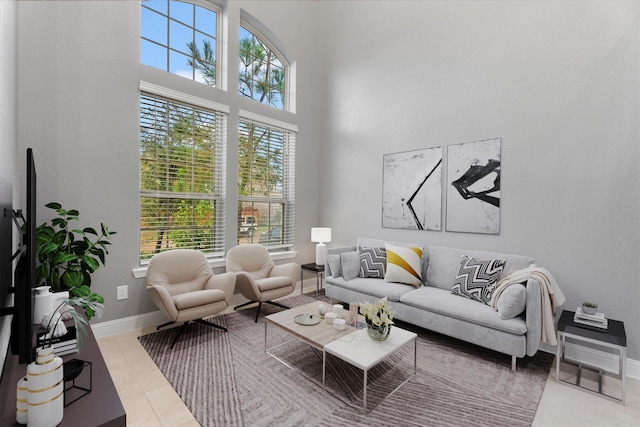 living room with tile patterned flooring and a high ceiling