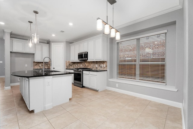 kitchen featuring a center island with sink, sink, tasteful backsplash, white cabinetry, and stainless steel appliances